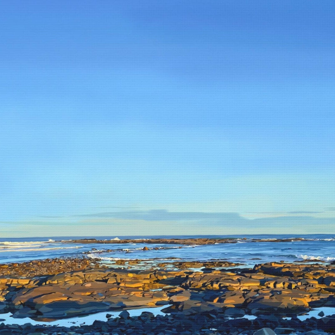 Beach scene with clear blue sky and rocky shoreline
