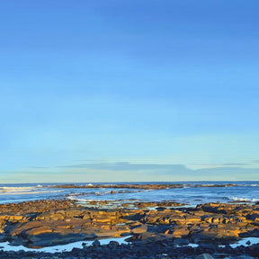 Beach scene with clear blue sky and rocky shoreline