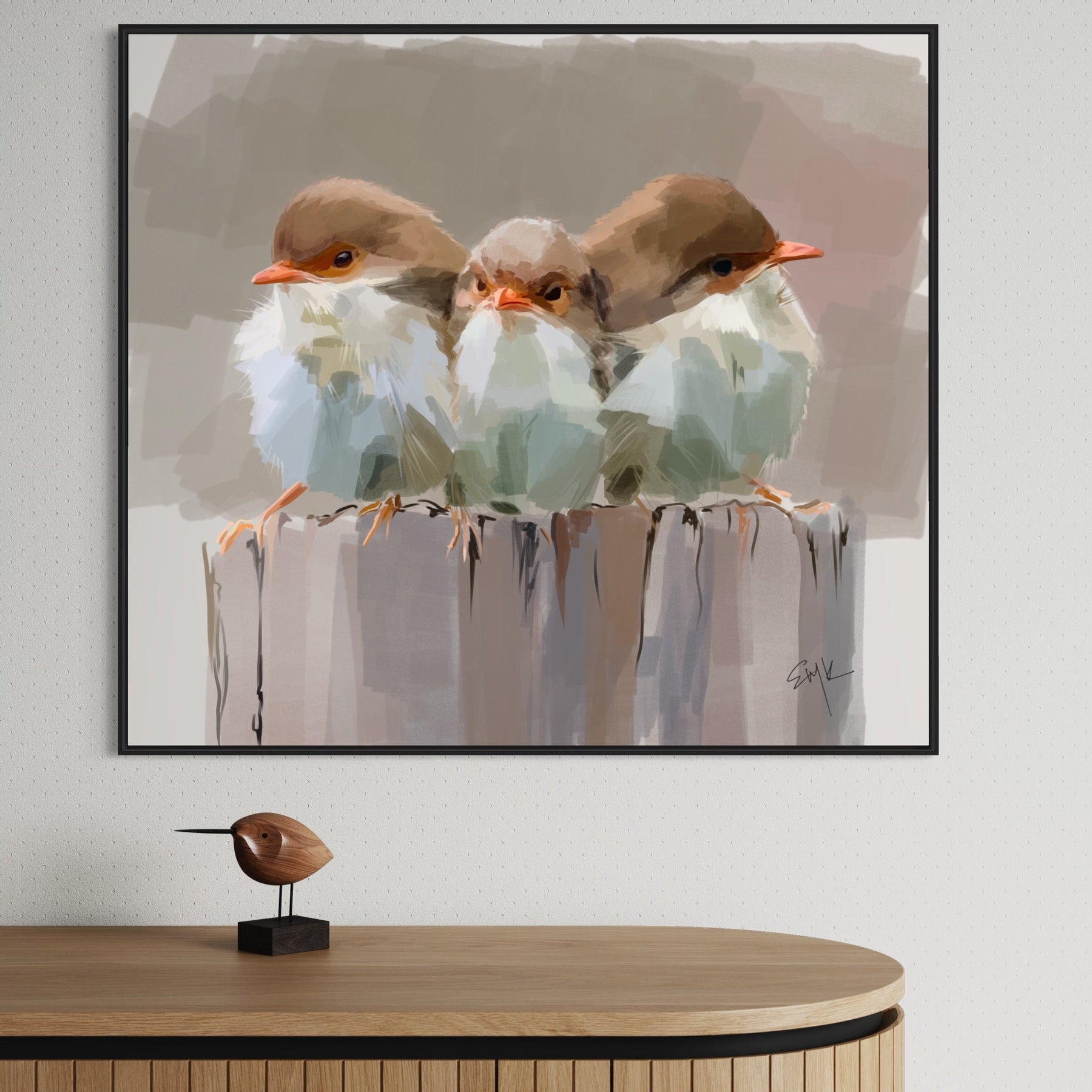 Framed artwork of three birds on a branch with a wooden cabinet below.