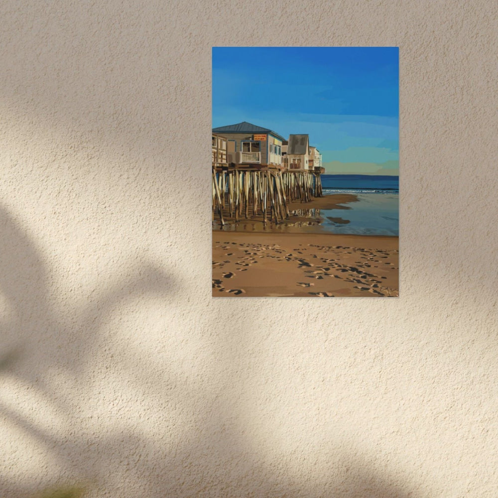 Beach scene with houses on stilts in a frame on a wall.