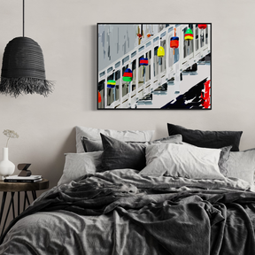 Bedroom with abstract art on the wall, plant, and side table.