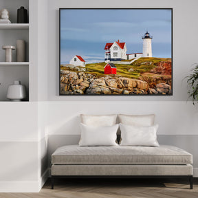 Living room with a sofa, plant, and wall art of a lighthouse.